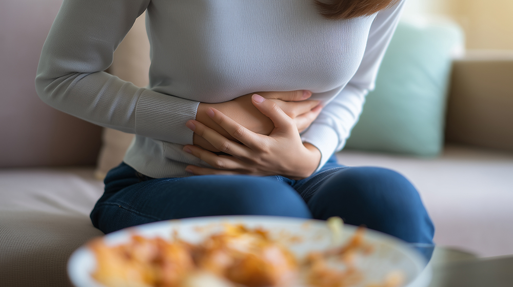 Close-up of woman experiencing stomach discomfort after eating,